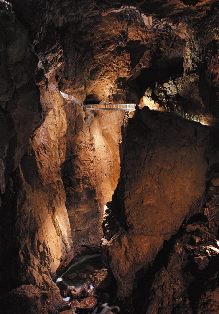 Researcher surveying a cave passage